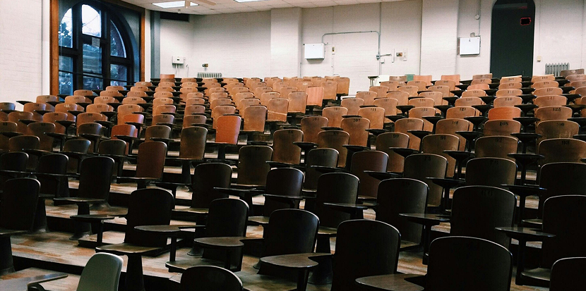 Amphith&eacute;&acirc;tre vide avec des rang&eacute;es de si&egrave;ges en bois.