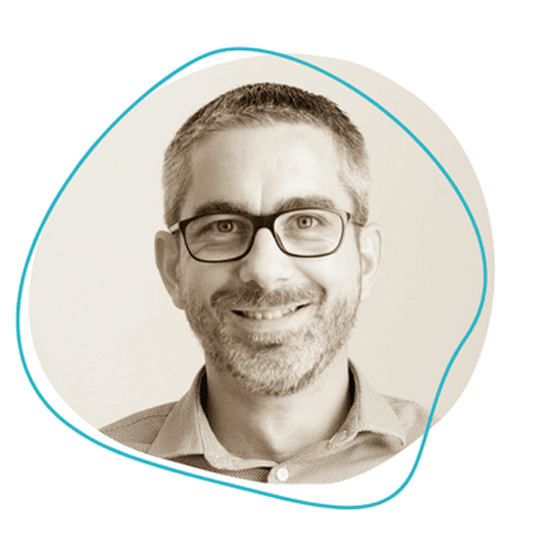 Homme souriant avec lunettes et barbe, fond graphique abstrait.