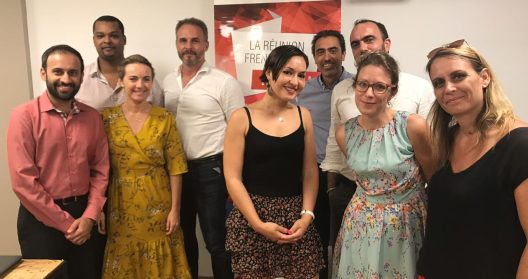 Groupe de personnes posant devant une affiche "La Réunion French Tech".
